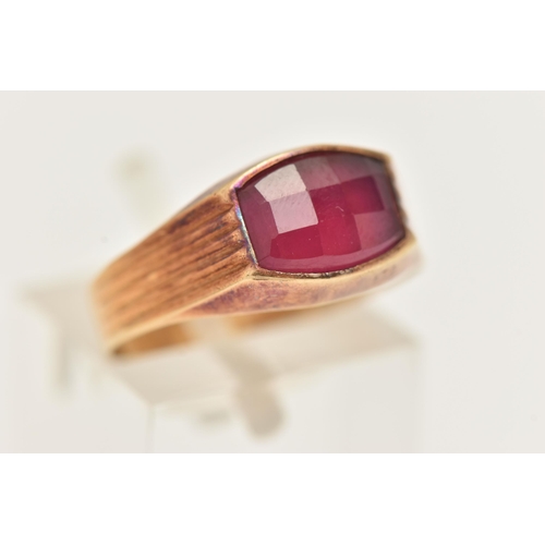 18 - A YELLOW METAL FANCY CUT RUBY RING, ruby collet set to the textured shoulders and polished band, rub... 