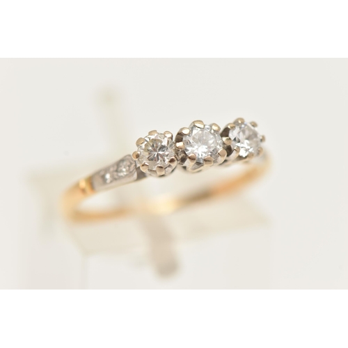 2 - A WHITE AND YELLOW METAL DIAMOND THREE STONE RING, set with slightly graduating round brilliant cut ... 