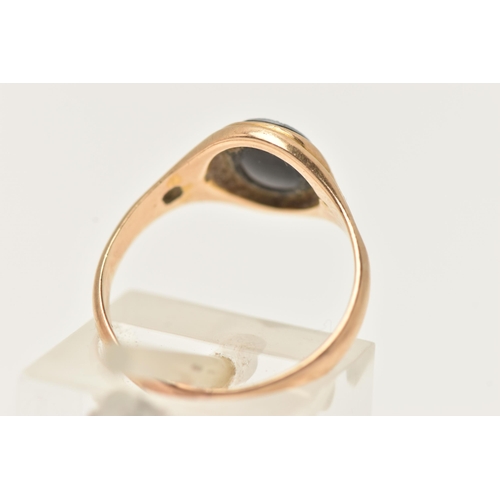 26 - A YELLOW METAL SARDONYX RING, of an oval form with a black and white sardonyx cameo, collet set to t... 