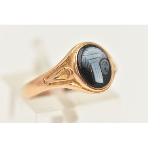 26 - A YELLOW METAL SARDONYX RING, of an oval form with a black and white sardonyx cameo, collet set to t... 