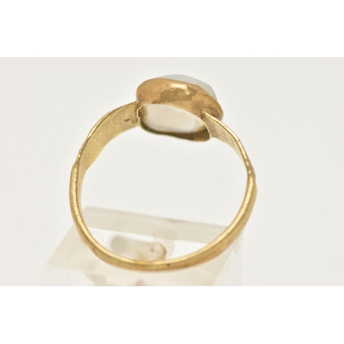 32 - A YELLOW METAL QUARTZ RING, set with a quartz cabochon stone, rough collet set to textured shoulders... 