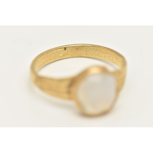 32 - A YELLOW METAL QUARTZ RING, set with a quartz cabochon stone, rough collet set to textured shoulders... 