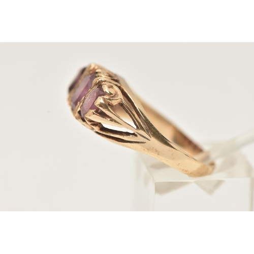 43 - A 9CT GOLD THREE STONE RING, set with three oval cut pink stones assesed as paste, to the scrolling ... 