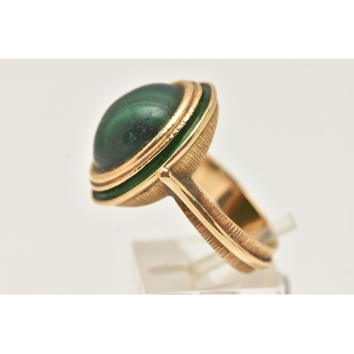 44 - A YELLOW METAL MALACHITE AND GREEN ENAMEL DRESS RING, of an oval form set with an oval cut malachite... 