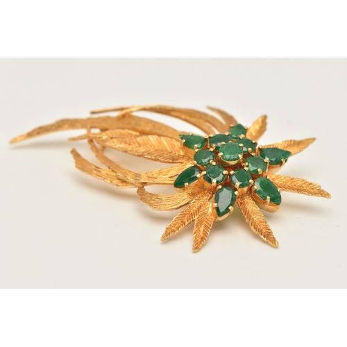 45 - A YELLOW METAL EMERALD SET SPRAY BROOCH, textured spray of leaves, set with a cluster of circular cu... 