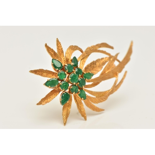 45 - A YELLOW METAL EMERALD SET SPRAY BROOCH, textured spray of leaves, set with a cluster of circular cu... 