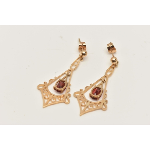 63 - A PAIR OF 9CT GOLD GARNET DROP EARRINGS, each designed with a central oval garnet drop within a scro... 