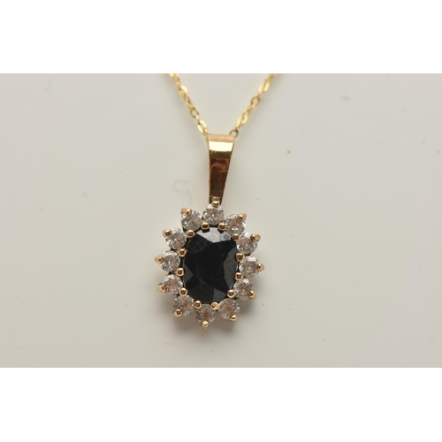 69 - A SAPPHIRE CLUSTER PENDANT AND CHAIN, designed as a central oval sapphire within a colourless paste ... 