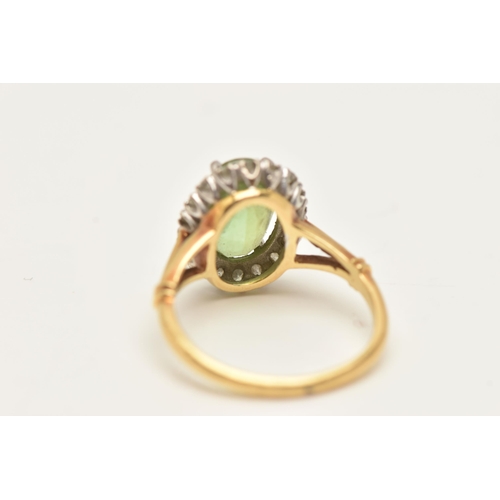 77 - A PERIDOT AND DIAMOND CLUSTER RING, the oval peridot within a single cut diamond surround, to the tr... 