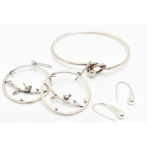 83 - A SILVER BANGLE, AND TWO PAIRS OF WHITE METAL EARRINGS, the bangle with lovers knot toggle style cla... 