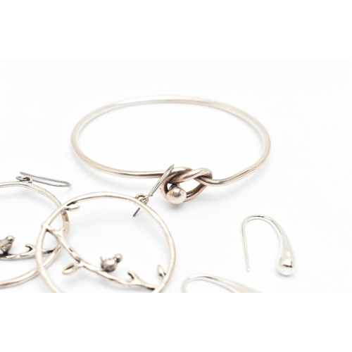 83 - A SILVER BANGLE, AND TWO PAIRS OF WHITE METAL EARRINGS, the bangle with lovers knot toggle style cla... 