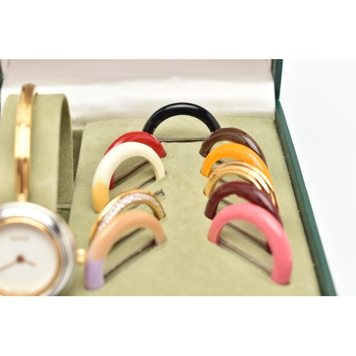 88 - A CASED GUCCI BANGLE WATCH WITH ELEVEN COLOURED INTERCHANGABLE BEZELS, WITH BOOKLET AND INTERNATIOAL... 