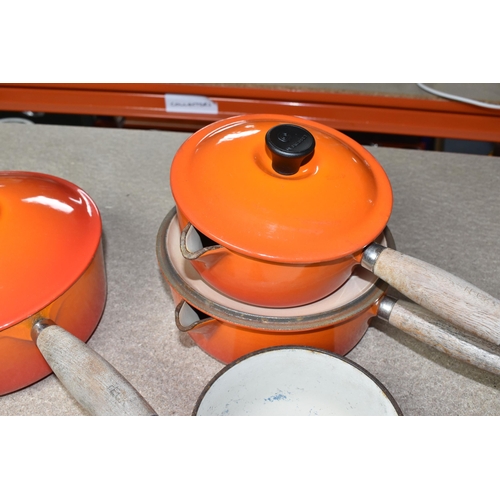 361 - FOUR LE CREUSET CAST IRON SAUCEPANS, in orange enamel with pouring lips and wooden handles, diameter... 