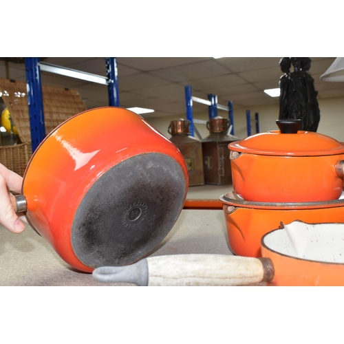 361 - FOUR LE CREUSET CAST IRON SAUCEPANS, in orange enamel with pouring lips and wooden handles, diameter... 