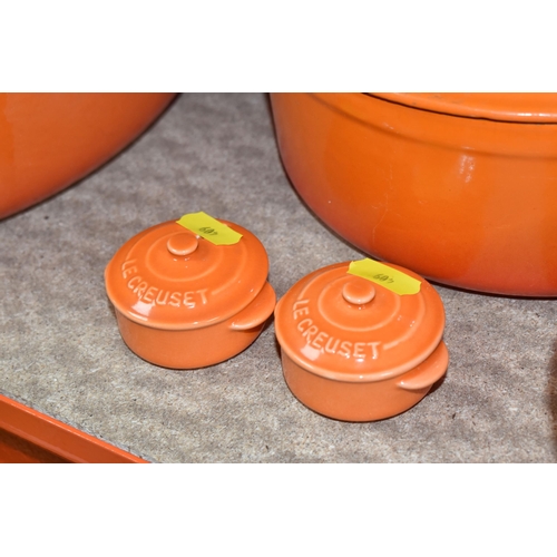 409 - LE CREUSET CAST IRON SAUCEPANS/ CASSEROLE POTS AND CRUET SET, in orange enamel outer finish and crea... 