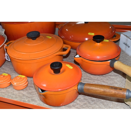 409 - LE CREUSET CAST IRON SAUCEPANS/ CASSEROLE POTS AND CRUET SET, in orange enamel outer finish and crea... 