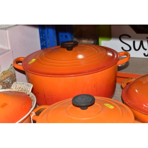 409 - LE CREUSET CAST IRON SAUCEPANS/ CASSEROLE POTS AND CRUET SET, in orange enamel outer finish and crea... 