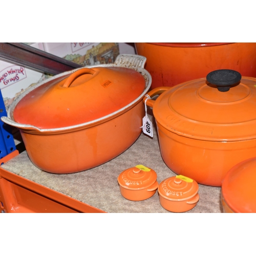 409 - LE CREUSET CAST IRON SAUCEPANS/ CASSEROLE POTS AND CRUET SET, in orange enamel outer finish and crea... 