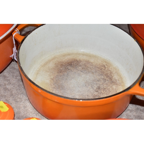 409 - LE CREUSET CAST IRON SAUCEPANS/ CASSEROLE POTS AND CRUET SET, in orange enamel outer finish and crea... 