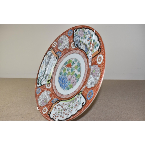 431 - A JAPANESE PORCELAIN CHARGER, painted with scroll-like panels depicting a lakeside scene with mounta... 