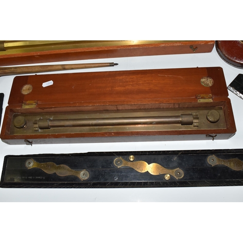 502 - A BOX OF TECHNICAL DRAWING EQUIPMENT, comprising two cased brass parallel rolling rules, four parall... 