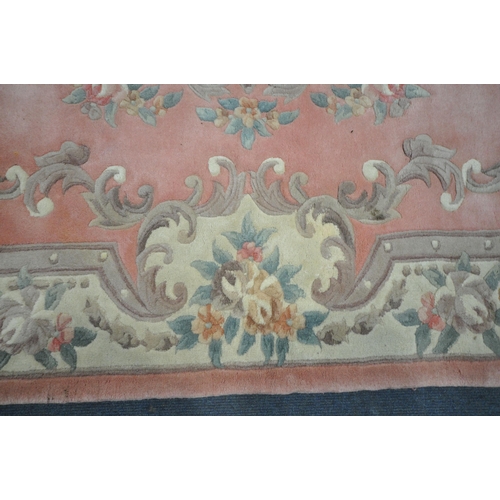 1204 - A LARGE PINK GROUND CHINESE WOOLLEN RUG, with a central medallion, repeating foliate patterns, unite... 