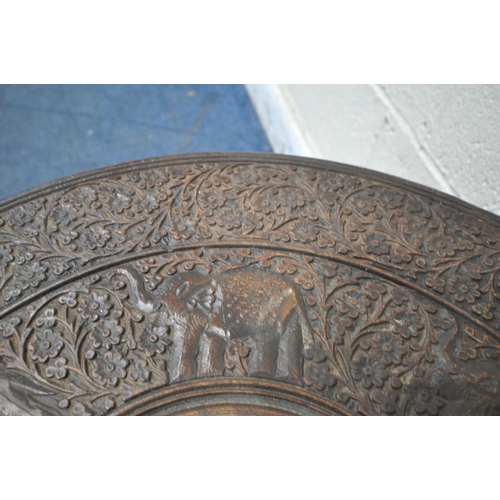 1208 - AN ANGLO INDIAN HARDWOOD CARVED TABLE, with repeating foliate and elephant details, a central copper... 