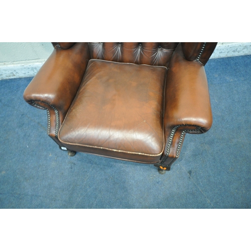 1242 - A TANNED BUTTONED LEATHER CHESTERFIELD WINGBACK ARMCHAIR, with scrolled armrests, raised on front ca... 