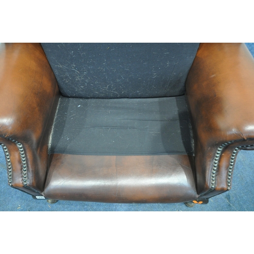 1242 - A TANNED BUTTONED LEATHER CHESTERFIELD WINGBACK ARMCHAIR, with scrolled armrests, raised on front ca... 