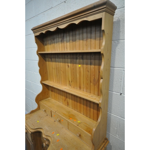 1284 - A 20TH CENTURY PINE DRESSER, the three tier plate rack with three drawers, atop a base with three dr... 