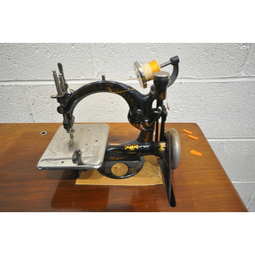 1288 - A WILLCOX AND GIBBS  AUTOMATIC  TREADLE SEWING MACHINE, with a mahogany case, raised on a wrought ir... 