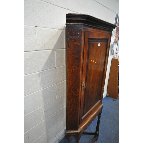 1290 - A GEORGIAN AND LATER OAK CORNER CUPBOARD ON STAND, with a single door, raised on turned front legs, ... 