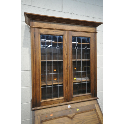 1295 - A 20TH CENTURY OAK BUREAU BOOKCASE, fitted with double lead glazed doors, atop a base with a fall fr... 