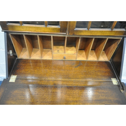 1296 - A 20TH CENTURY OAK BUREAU BOOKCASE, with double glazed doors, atop a base with a fall front door, ab... 