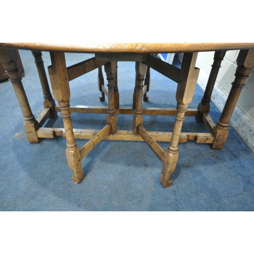 1298 - AN 18TH CENTURY STYLE OAK WAKE TABLE, raised on block and turned legs, open width 143cm x closed wid... 