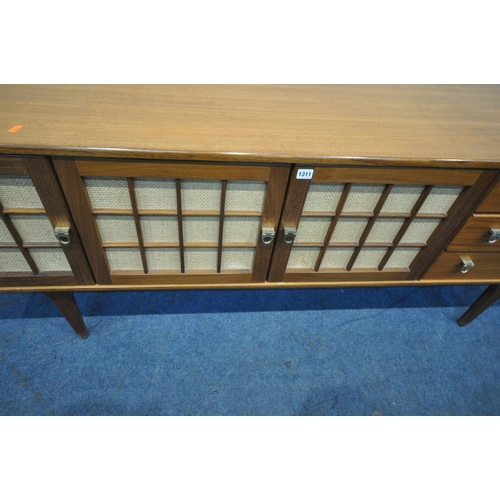 1311 - HERBERT GIBBS FOR YOUNGER, A MID CENTURY TEAK SIDEBOARD, fitted with three cupboard doors, and three... 