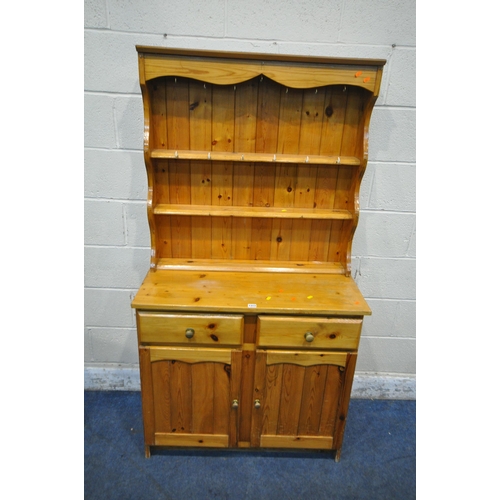 1313 - A MODERN PINE DRESSER, the three tier plate rack, atop a base fitted with two drawers, above two cup... 