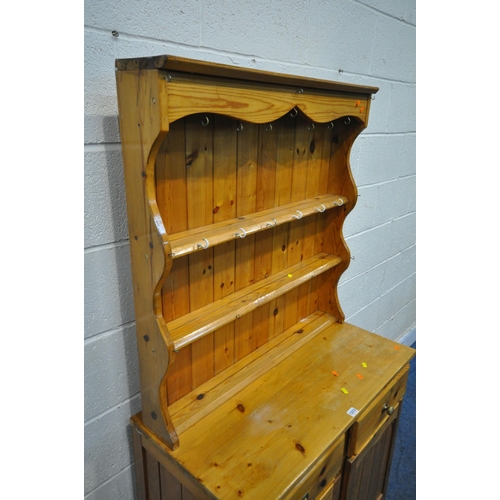 1313 - A MODERN PINE DRESSER, the three tier plate rack, atop a base fitted with two drawers, above two cup... 