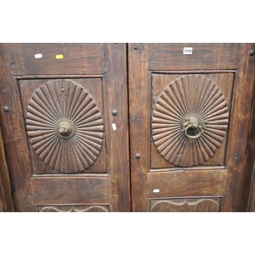 1330 - A HEAVY CARVED EASTERN HARDWOOD DOUBLE DOORS, within a moulded frame, the doors with reeded rosette ... 