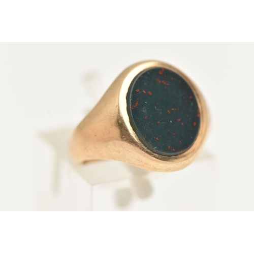 37 - A YELLOW METAL BLOODSTONE SIGNET RING, of an oval form, set with a polished bloodstone inlay, to a p... 