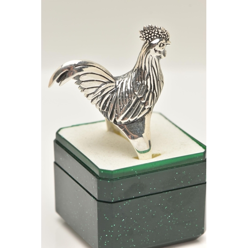 70 - A LARGE WHITE METAL RING, designed as a chicken, leading on to a tapered shank, approximate height 2... 