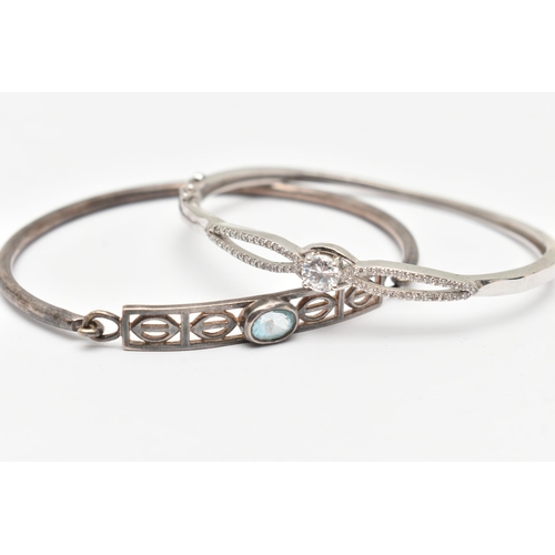 76 - TWO WHITE METAL BANGLES, the first a white metal hinged bangle set with cubic zirconia, the second a... 