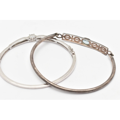 76 - TWO WHITE METAL BANGLES, the first a white metal hinged bangle set with cubic zirconia, the second a... 