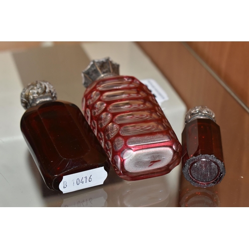 305 - THREE VICTORIAN CRANBERRY GLASS SCENT BOTTLES, comprising two cut cranberry glass bottles with flora... 