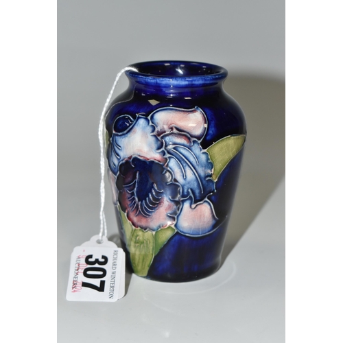 307 - A BLUE MOORCROFT 'ORCHID' VASE with a tube lined orchid pattern on a cobalt blue ground, height 10cm... 