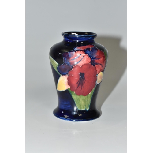 318 - A BLUE MOORCROFT POTTERY 'ORCHID' VASE with a tube lined orchid pattern on a cobalt blue ground, hei... 