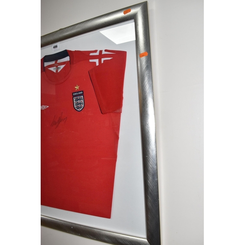 486 - A FRAMED ENGLAND FOOTBALL SHIRT, bearing signature, an official Umbro product red England Away footb... 