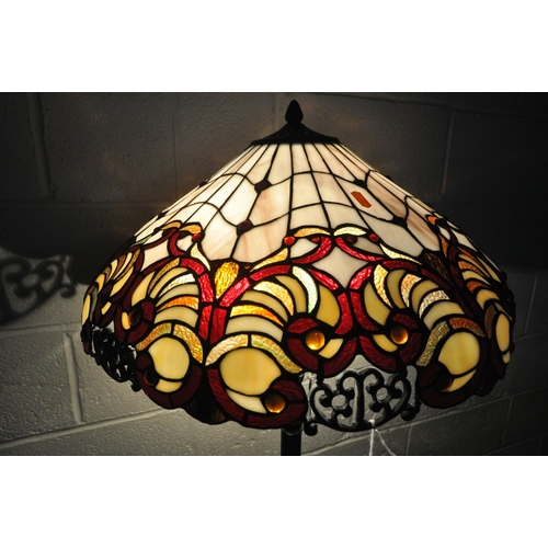 155 - A PAIR OF TIFFANY STYLE STANDARD LAMPS, the shade with coloured scrolled details, the pillar support... 