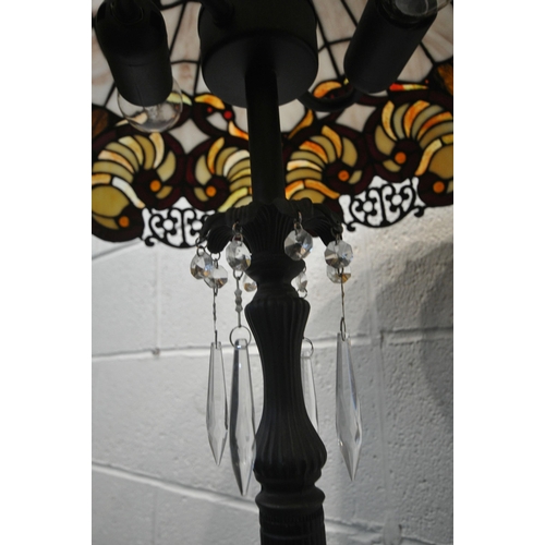 155 - A PAIR OF TIFFANY STYLE STANDARD LAMPS, the shade with coloured scrolled details, the pillar support... 