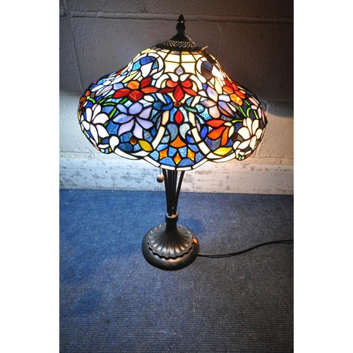 156 - A TIFFANY STYLE TABLE LAMP, the shade with foliate details, of various colours, raised on a shaped s... 